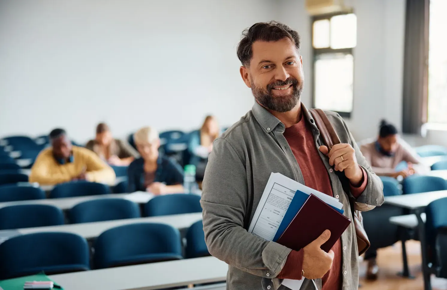 Happy mature man attending adult education training course and looking at camera.