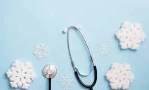 blue background with stethoscope and snowflakes, medical winter holiday. copy space