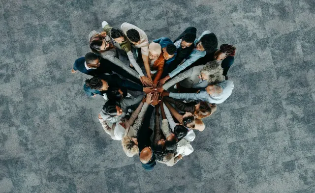 A diverse business group standing in a heart formation, symbolizing unity, teamwork, and collaboration.